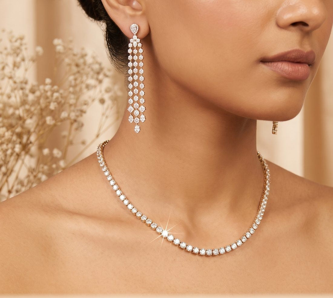 A woman wearing a lab-grown diamond tennis necklace and drop earrings